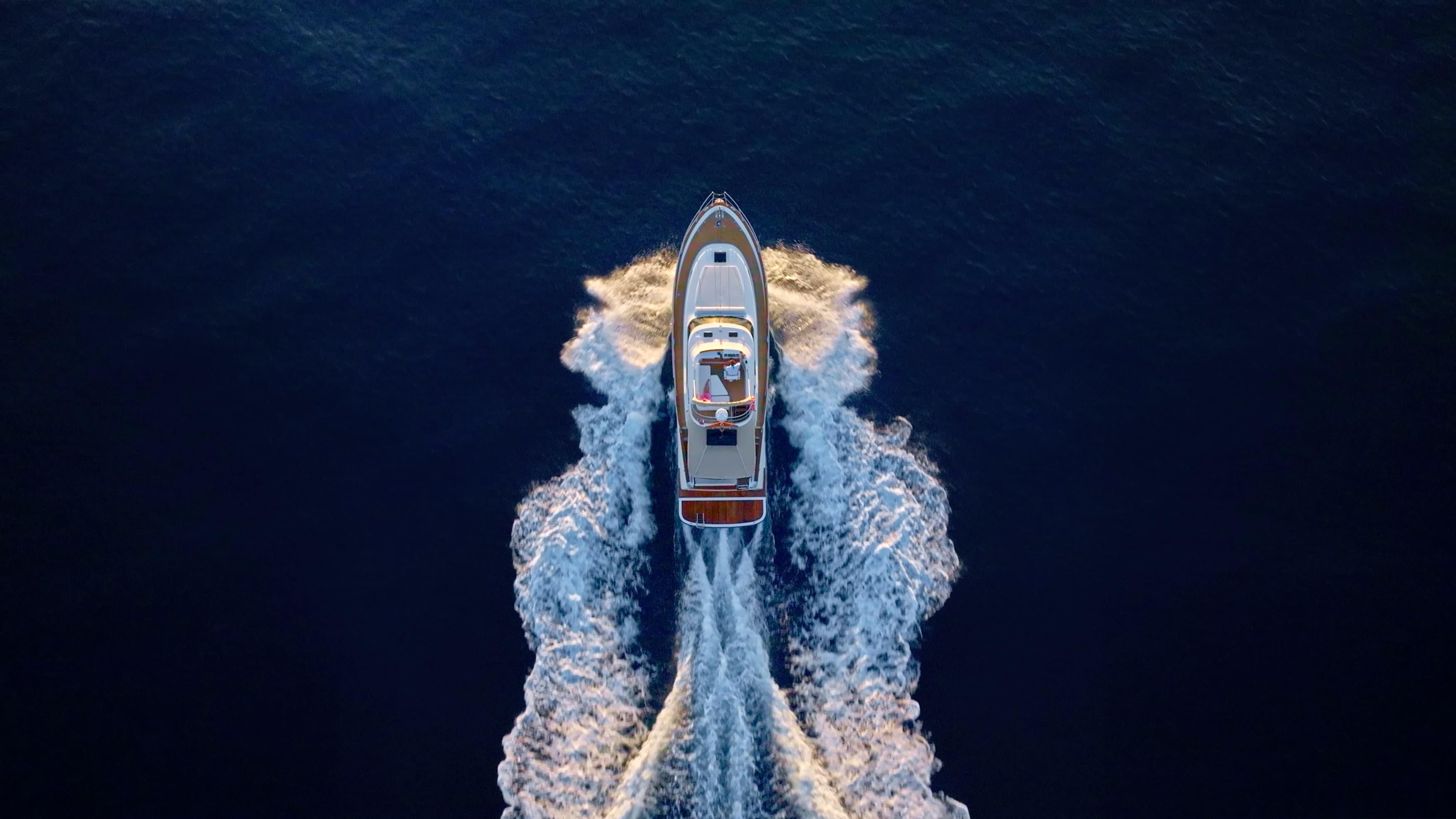 Aerial view of a motor yacht under way leaving a long wake